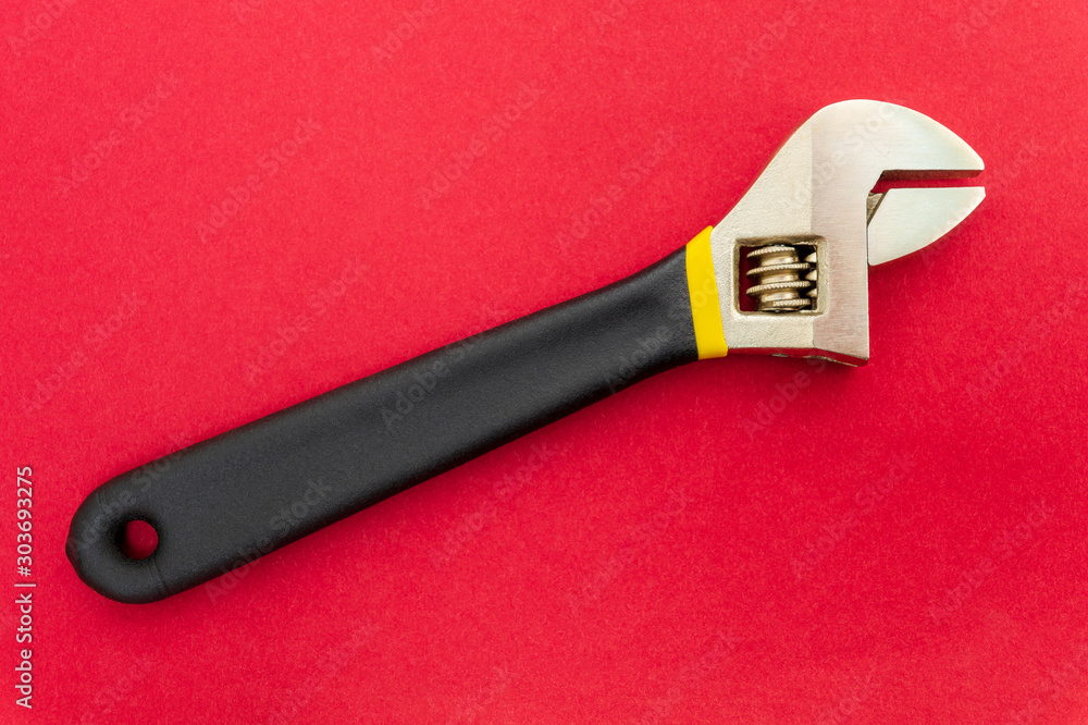 Obraz premium New adjustable spanner on a red background