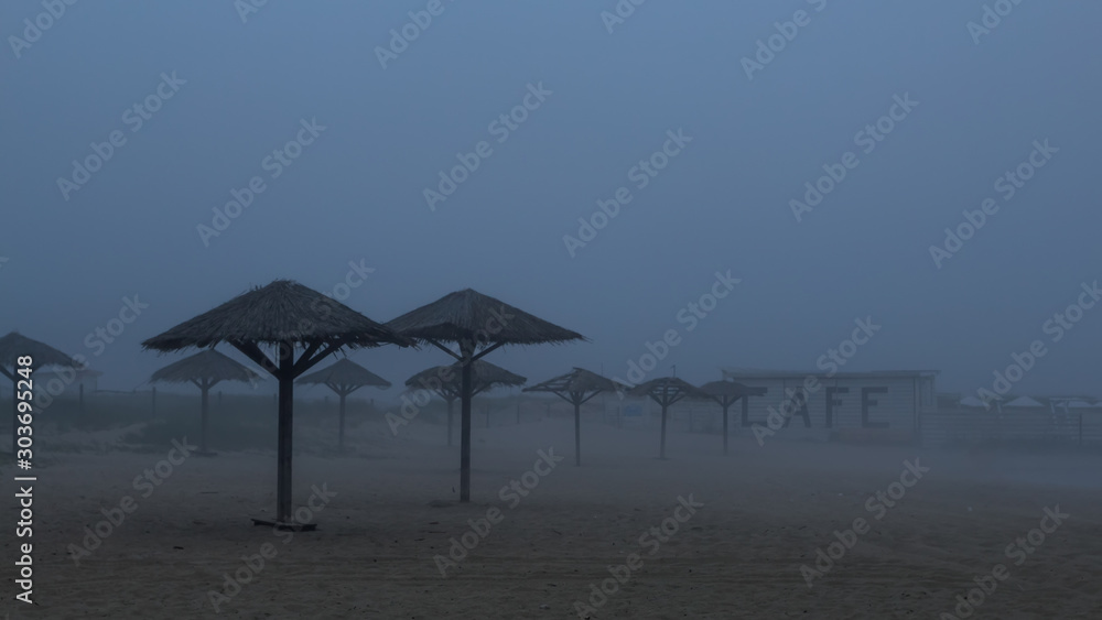 umbrellas made from cane on the beach on a foggy day