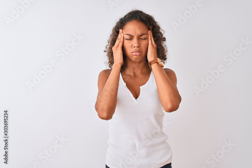 Young brazilian woman wearing casual t-shirt standing over isolated white background with hand on headache because stress. Suffering migraine.