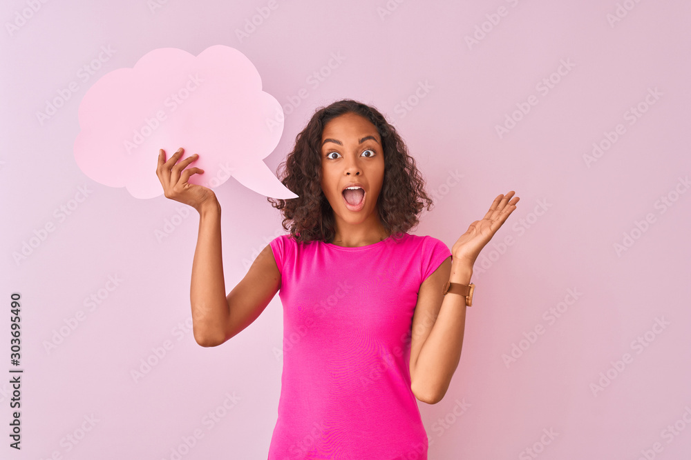 Young brazilian woman holding cloud speech bubble standing over isolated pink background very happy and excited, winner expression celebrating victory screaming with big smile and raised hands Young brazilian woman holding cloud speech bubble standing over isolated pink background very happy and excited, winner expression celebrating victory screaming with big smile and raised hands