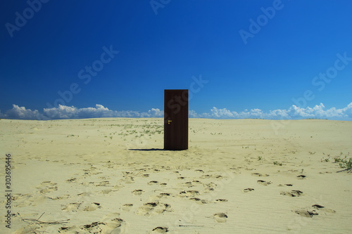 wooden door in the middle of the desert, sand and clear sky