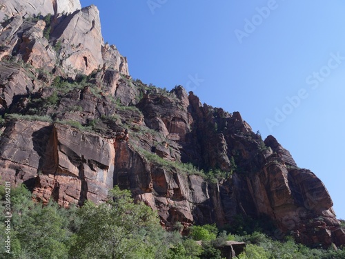 Sides of the steep red cliffs in shadows cast in early afternoon shadows at Zion National Park, Utah