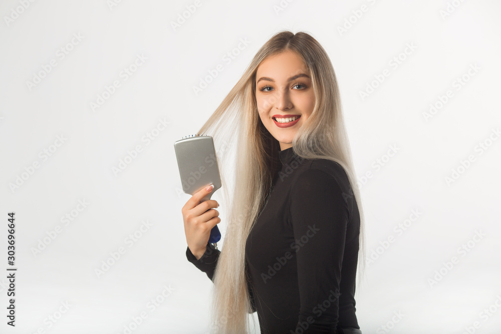 beautiful young woman with long hair on a white background combs her hair beautiful young woman with long hair on a white background combs her hair