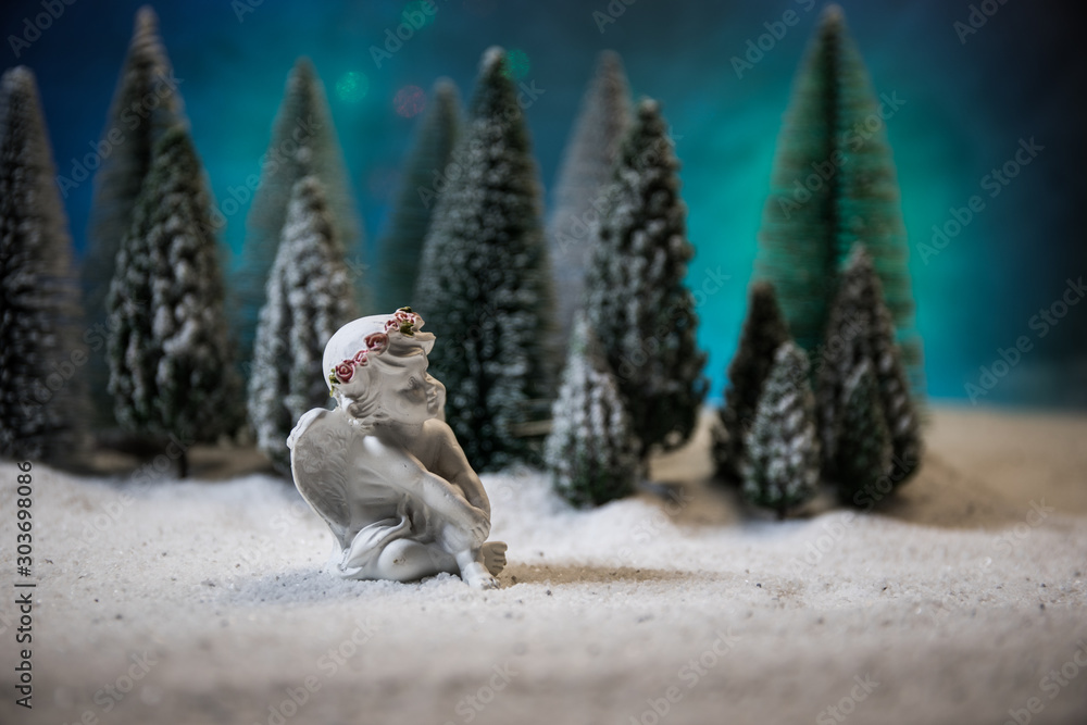 Obraz premium Little white guardian angel in snow. Festive background. Christmas decorations.