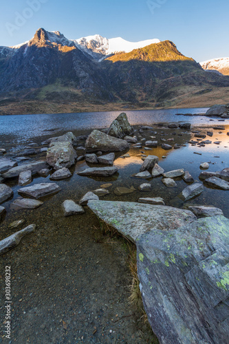 Fototapeta Naklejka Na Ścianę i Meble -  Early morning light and shadow over mountains and snow. Y Garn from Cwm Idwal. Lake or Llyn Idwal in foreground. portrait