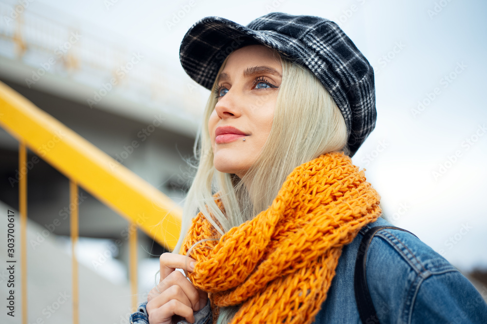 Φωτογραφία Portrait of young blonde teenage smiling girl, wearing orange scarf and plaid cap