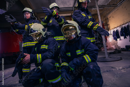 Portrait of group firefighters in front of firetruck inside the fire station