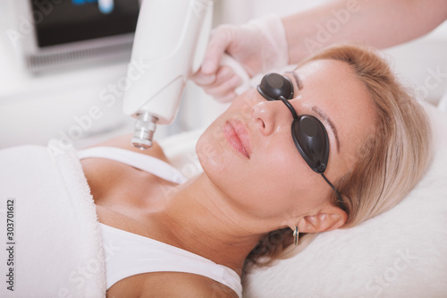 Fotografija Cropped shot of a professional cosmetologist removing skin pigmentation on the shoulder of female client