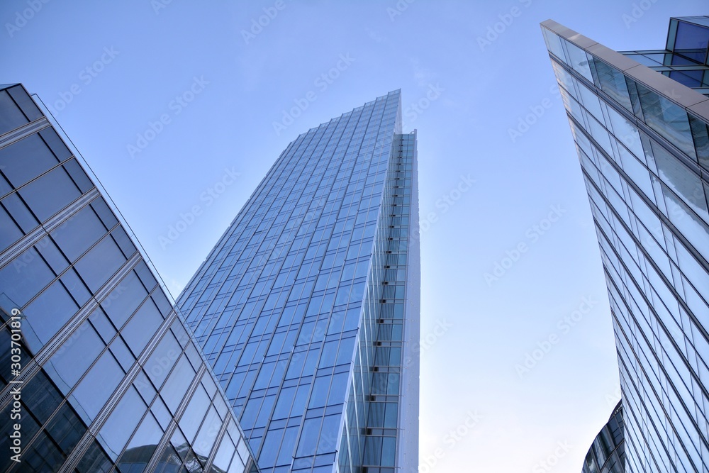 Modern office building wall made of steel and glass with blue sky Modern office building wall made of steel and glass with blue sky