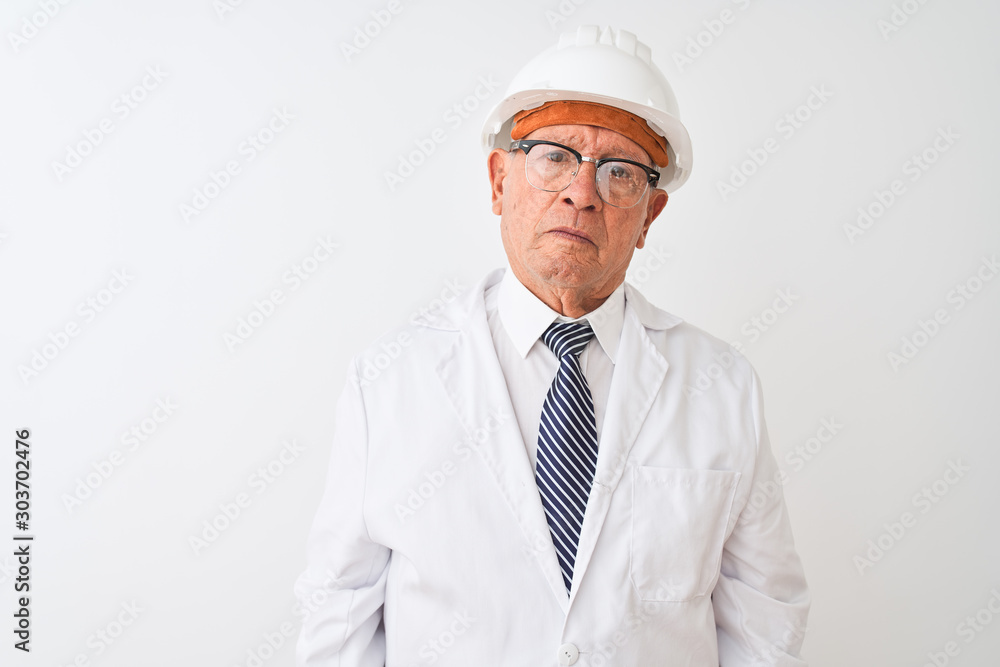 Senior grey-haired engineer man wearing coat and helmet over isolated white background with serious expression on face. Simple and natural looking at the camera. Senior grey-haired engineer man wearing coat and helmet over isolated white background with serious expression on face. Simple and natural looking at the camera.