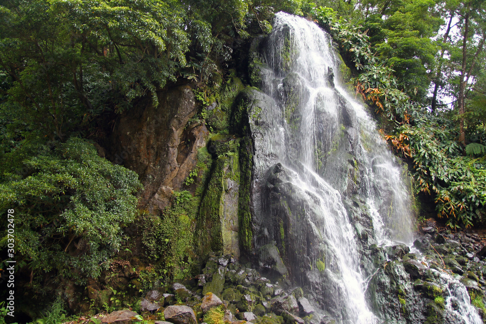 Impressing waterfall in the green nature of Azores islands