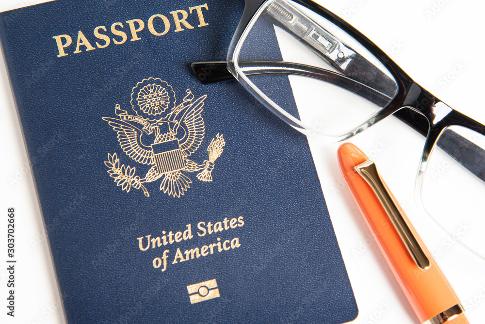 Φωτογραφία An American passport with a pair of reading glasses and an orange fountain pen