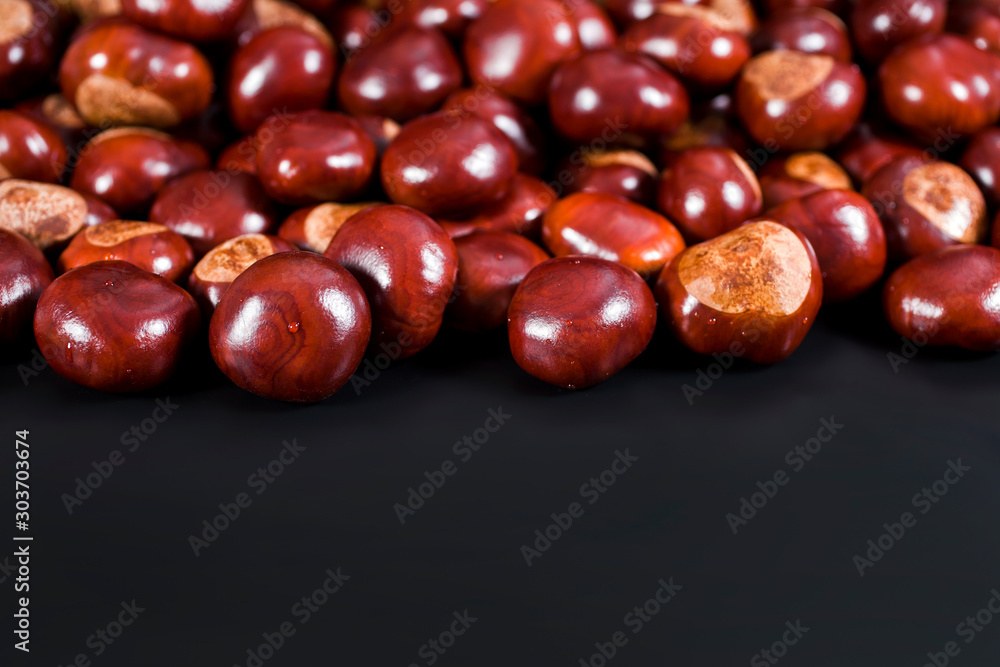 Background of chestnuts on a black table. Selective focus. Background of chestnuts on a black table. Selective focus.