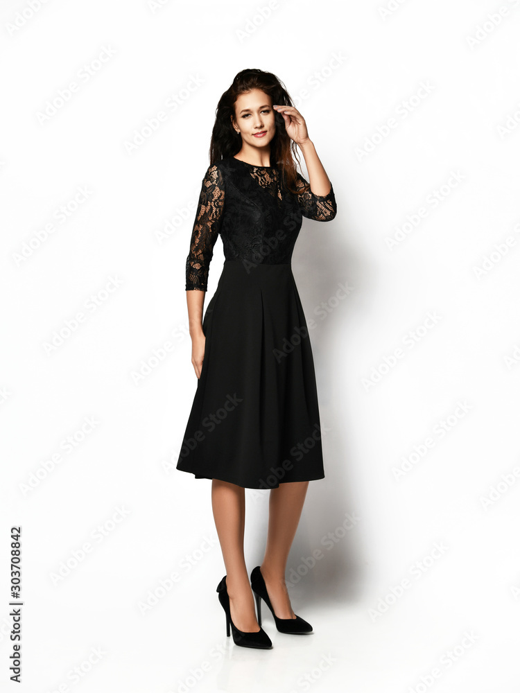 Slim beauty female model in an autumn dark long dress looking at the camera in full body growth Slim beauty female model in an autumn dark long dress looking at the camera in full body growth