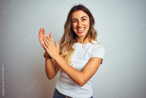 Tableau sur toile Young beautiful woman wearing casual white t-shirt over isolated background clap