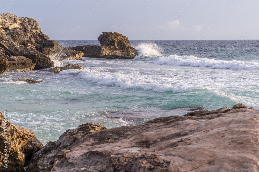 Caribbean sea coast with rocks and hello breaking