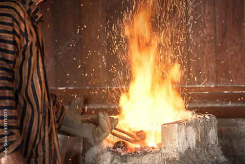 Blacksmith heat up the molten metal to make keris photo