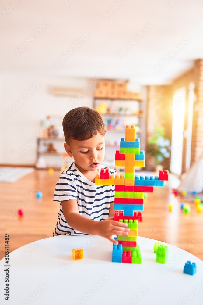 Beautiful toddler boy playing with construction blocks at kindergarten Beautiful toddler boy playing with construction blocks at kindergarten