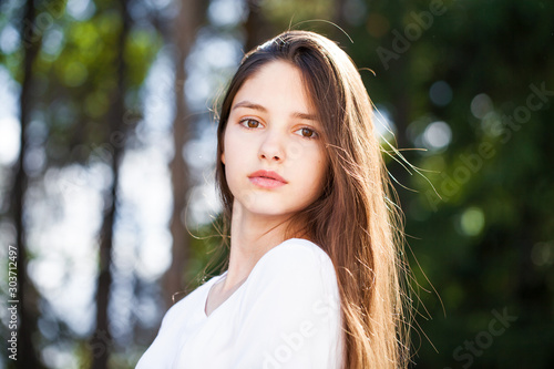 Close up brunette girl in summer park background