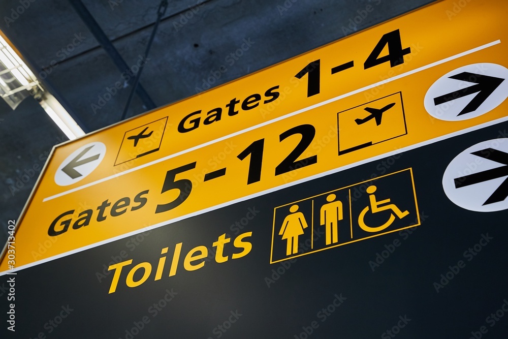 Toilets and gate signs in an airport terminal - obrazy, fototapety, plakaty 