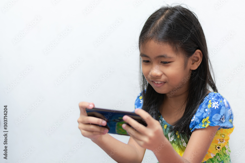 Children's concepts of technology and communication - Smiling girls using their smartphones on white background with copy space. Children's concepts of technology and communication - Smiling girls using their smartphones on white background with copy space.