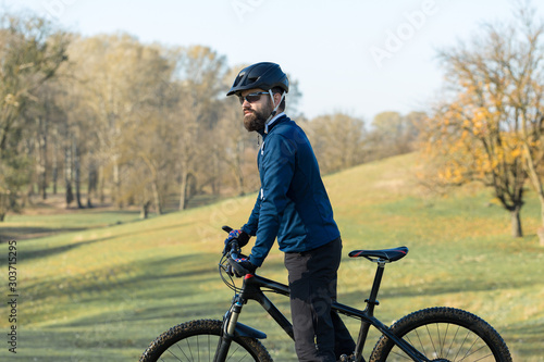 Fototapeta Naklejka Na Ścianę i Meble -  Cyclist in pants and fleece jacket on a modern carbon hardtail bike with an air suspension fork rides off-road.	