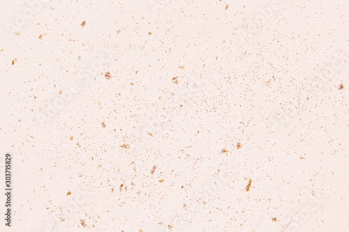 Pink champagne color glitter on light wood. Holiday celebration background. Close up, copy space