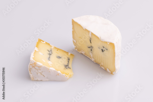 Blue cheese with white surface, isolated on white background, soft light, studio photo. Mix of gorgonzola and camembert / brie cheese.