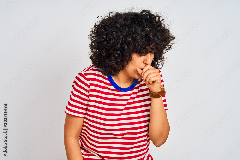 Young arab woman with curly hair wearing striped t-shirt over isolated white background feeling unwell and coughing as symptom for cold or bronchitis. Healthcare concept. Young arab woman with curly hair wearing striped t-shirt over isolated white background feeling unwell and coughing as symptom for cold or bronchitis. Healthcare concept.