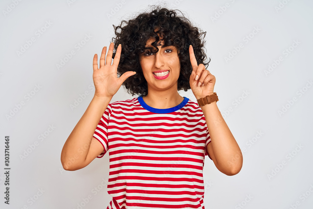 Young arab woman with curly hair wearing striped t-shirt over isolated white background showing and pointing up with fingers number six while smiling confident and happy. Young arab woman with curly hair wearing striped t-shirt over isolated white background showing and pointing up with fingers number six while smiling confident and happy.