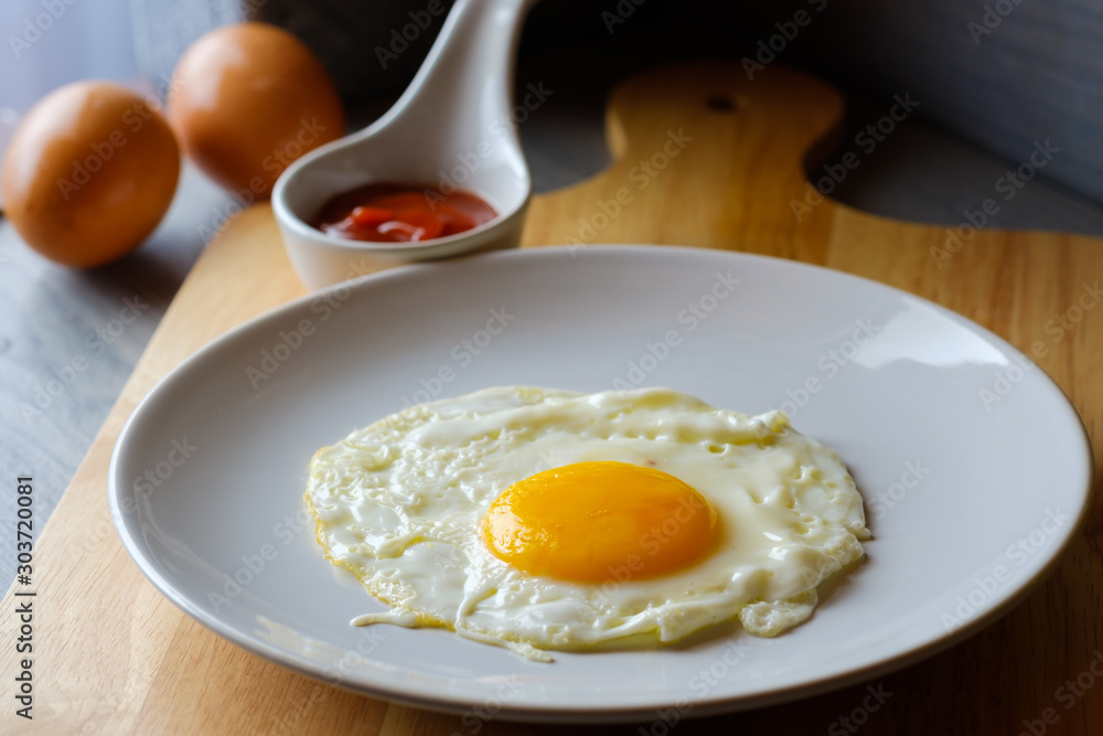 Close up fried egg is in a white round dish placed Close up fried egg is in a white round dish placed
