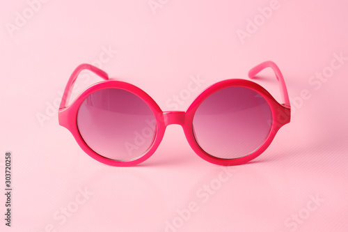 Red glasses on pink background with copy space
