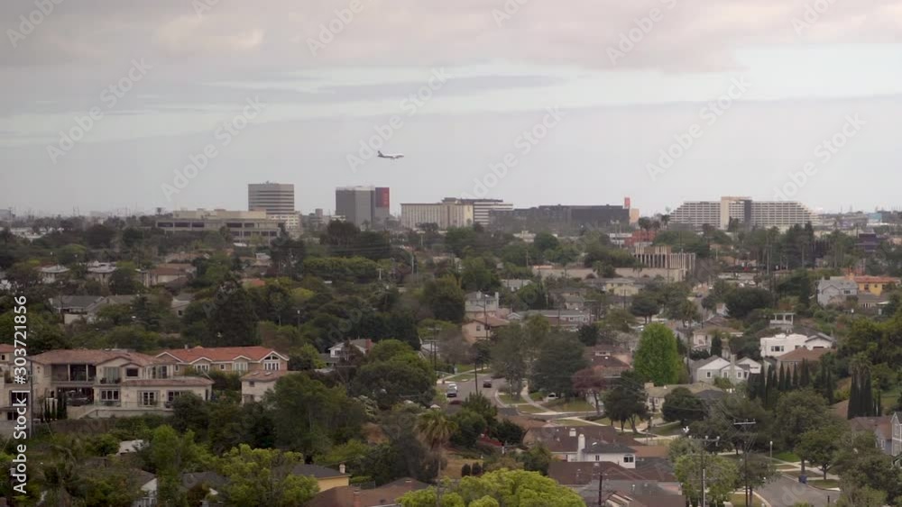 Plane flying low over building and neighborhoods landing beyond the horizon. Plane flying low over building and neighborhoods landing beyond the horizon.