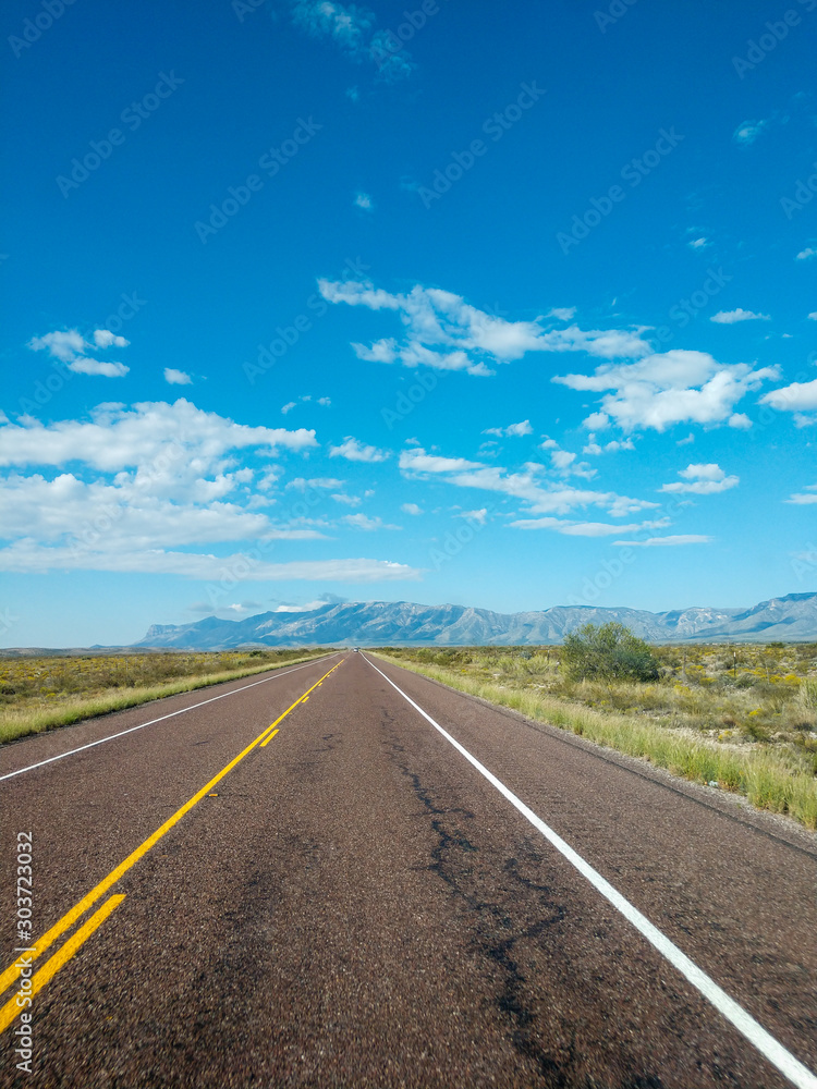 Fototapeta premium Asphalt road in the mountains with soft sky on the background.