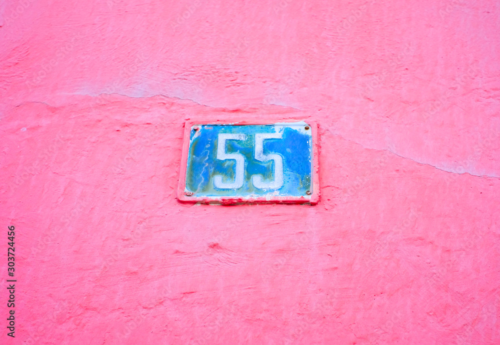 Joyfull blue 55, number fifty-five, on a pink wall. Joyfull blue 55, number fifty-five, on a pink wall.