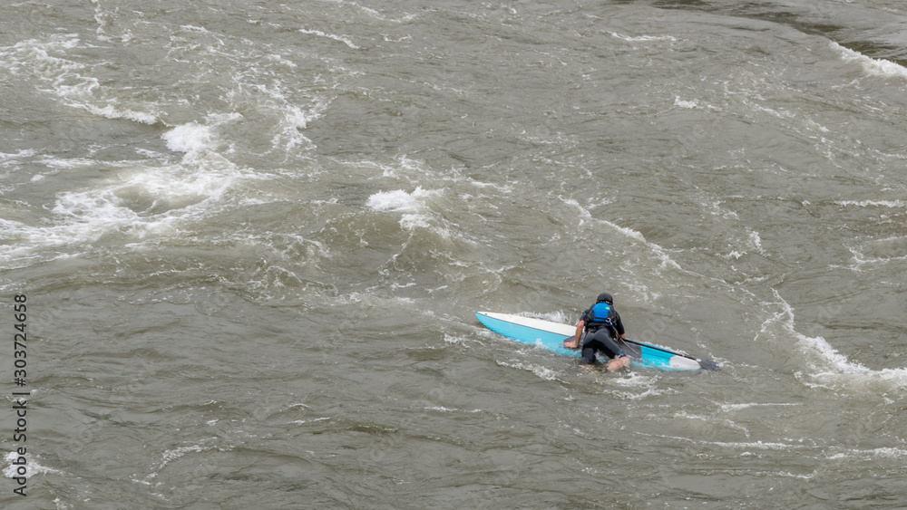 Naklejka premium Man on Kayak in wetsuit on kayak on the river
