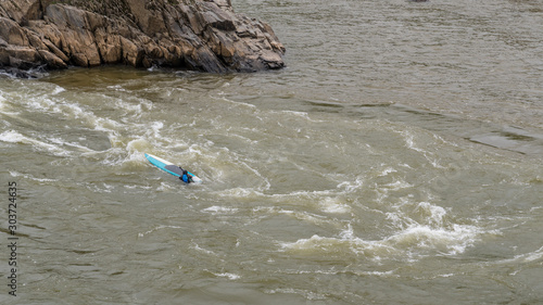 Man on Kayak in wetsuit on kayak on the river