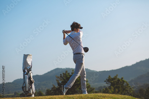 Side view, Asian Man hiting golf ball on the golf course in summer. sport, golfer concept.