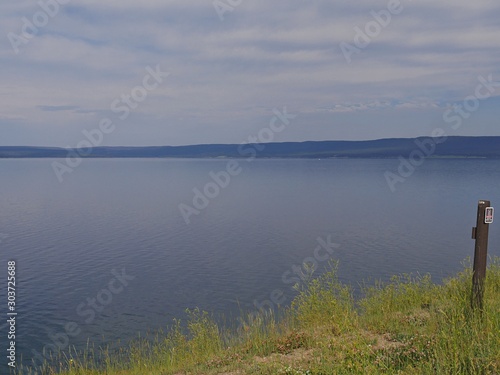 Yellowstone Lake with green grass at the banks at the Yellowstone National Park, Wyoming.