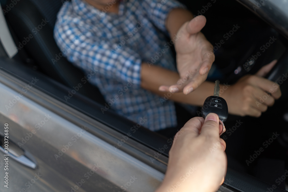 Man sitting in car and receive car key from dealer. Auto business, car sale or rental consumerism business, people transport automobile service or insurance concept.