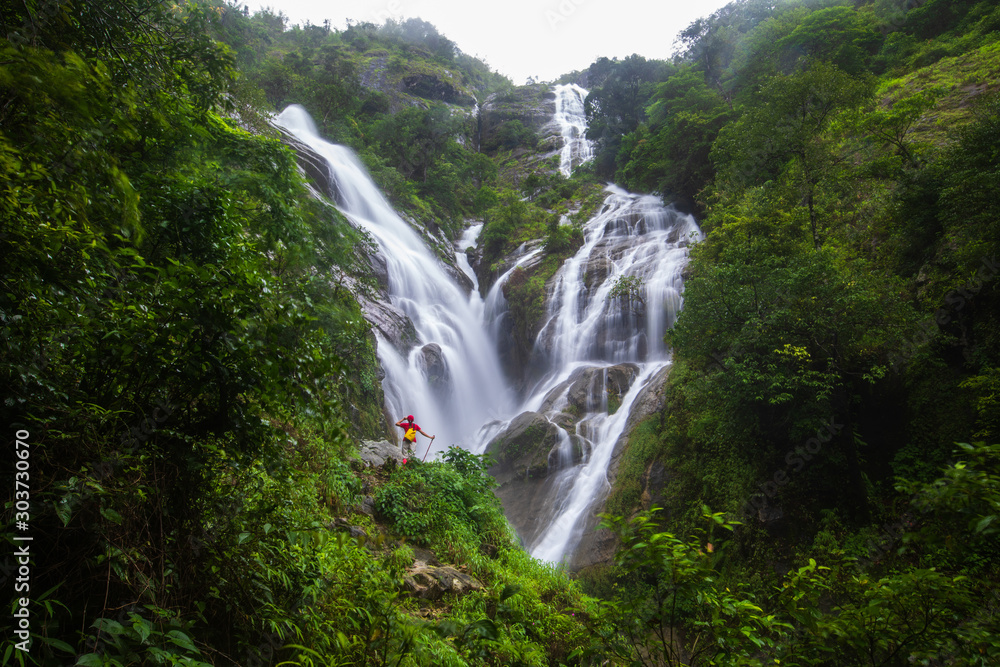 Young girl  hiking  on Pi-tu-gro waterfall, Beautiful waterfall in Tak  province, ThaiLand.