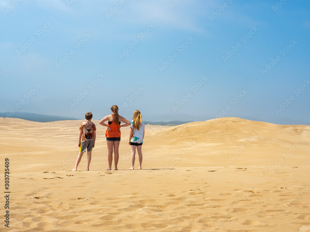 three kids in the sand