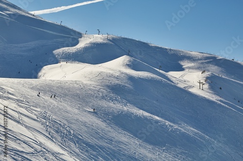 Ski slopes in the French Alpes, people skiing in the distance