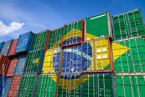 The national flag of Brazil on a large number of metal containers for storing goods stacked in rows on top of each other. Conception of storage of goods by importers, exporters
