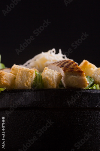 closeup of a salad bowl with lettuce bread cheese and grilled chicken photo