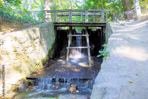 wooden bridge with railings above  river in park under trees. Uman Ukraine photo