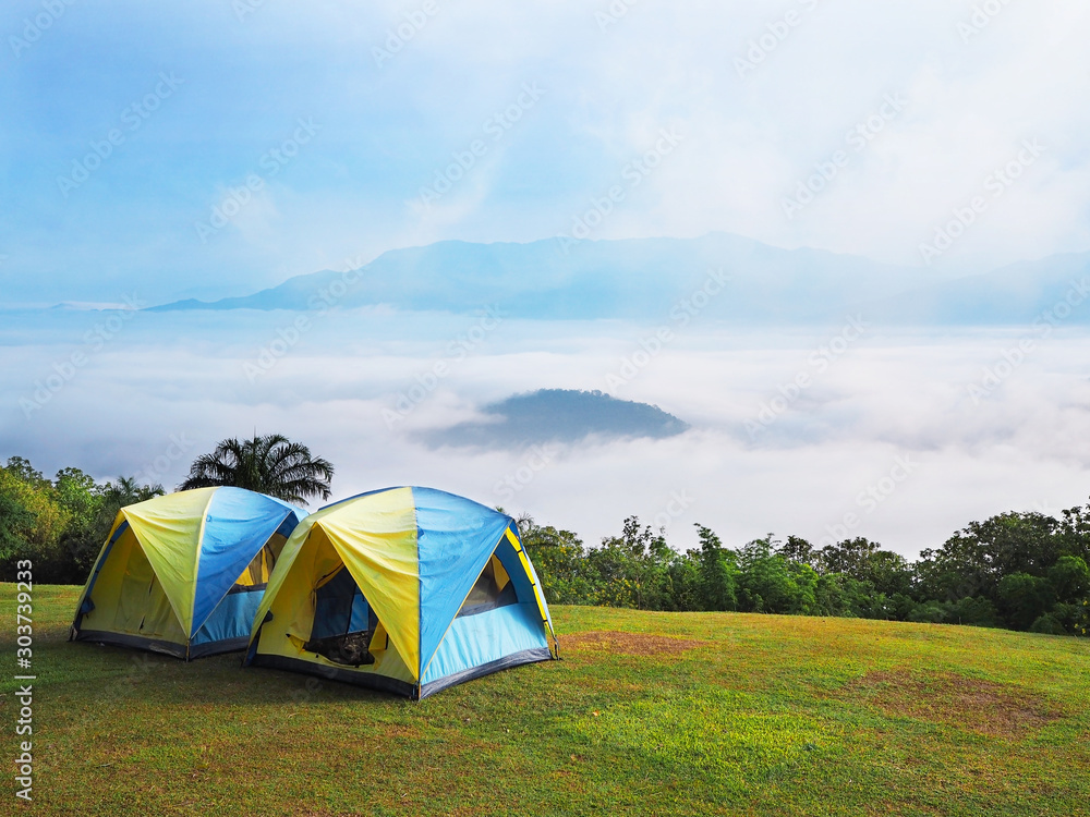 tourist tents on high mountain with blue sky and white cloud fog background.