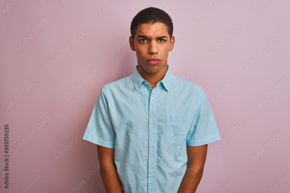 Young handsome arab man wearing blue shirt standing over isolated pink background skeptic and nervous, frowning upset because of problem. Negative person. Young handsome arab man wearing blue shirt standing over isolated pink background skeptic and nervous, frowning upset because of problem. Negative person.