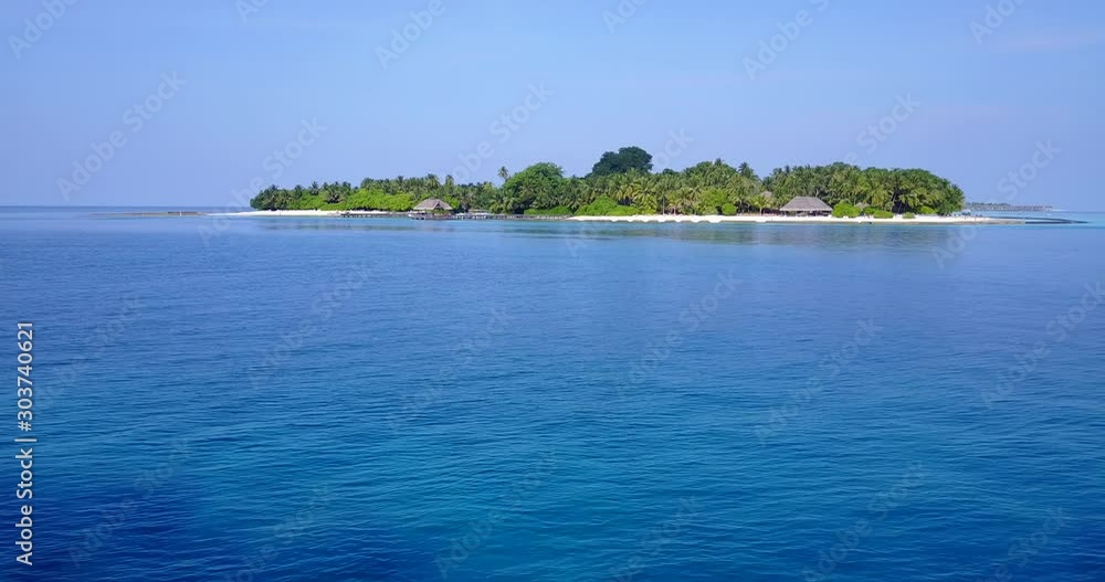 Paradise tropical island seen from blue azure calm sea surface around it under clear light blue sky on a peaceful vacation day in Caribbean Paradise tropical island seen from blue azure calm sea surface around it under clear light blue sky on a peaceful vacation day in Caribbean