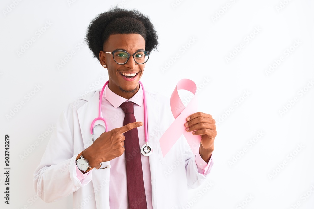 Young african american doctor man holding cancer ribbon over isolated white background very happy pointing with hand and finger Young african american doctor man holding cancer ribbon over isolated white background very happy pointing with hand and finger